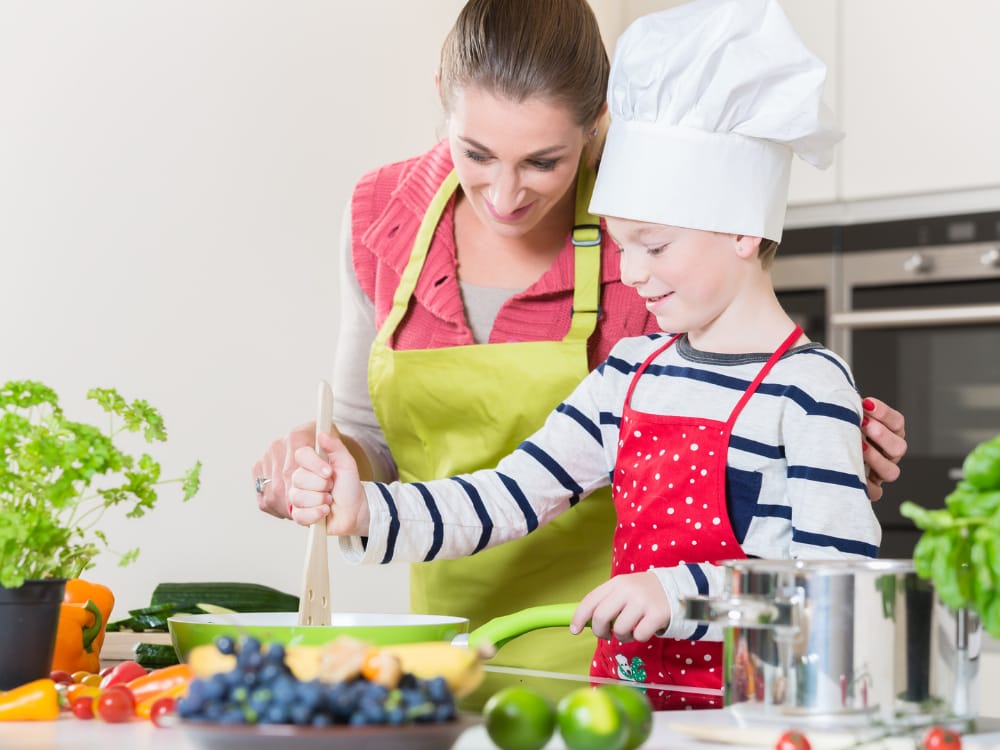 Mãe cozinhando uma refeição com seu filho.