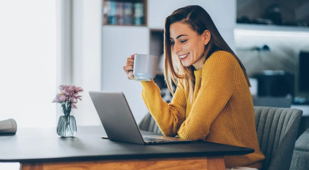 mulher trabalhando online no seu laptop na sala de sua casa